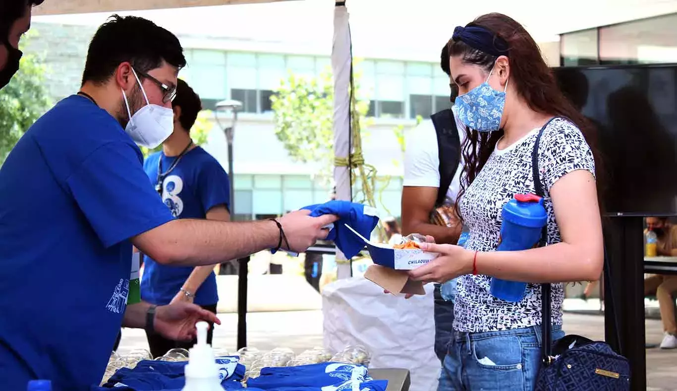 Alumno entregando playera del 78 Aniversario del Tec