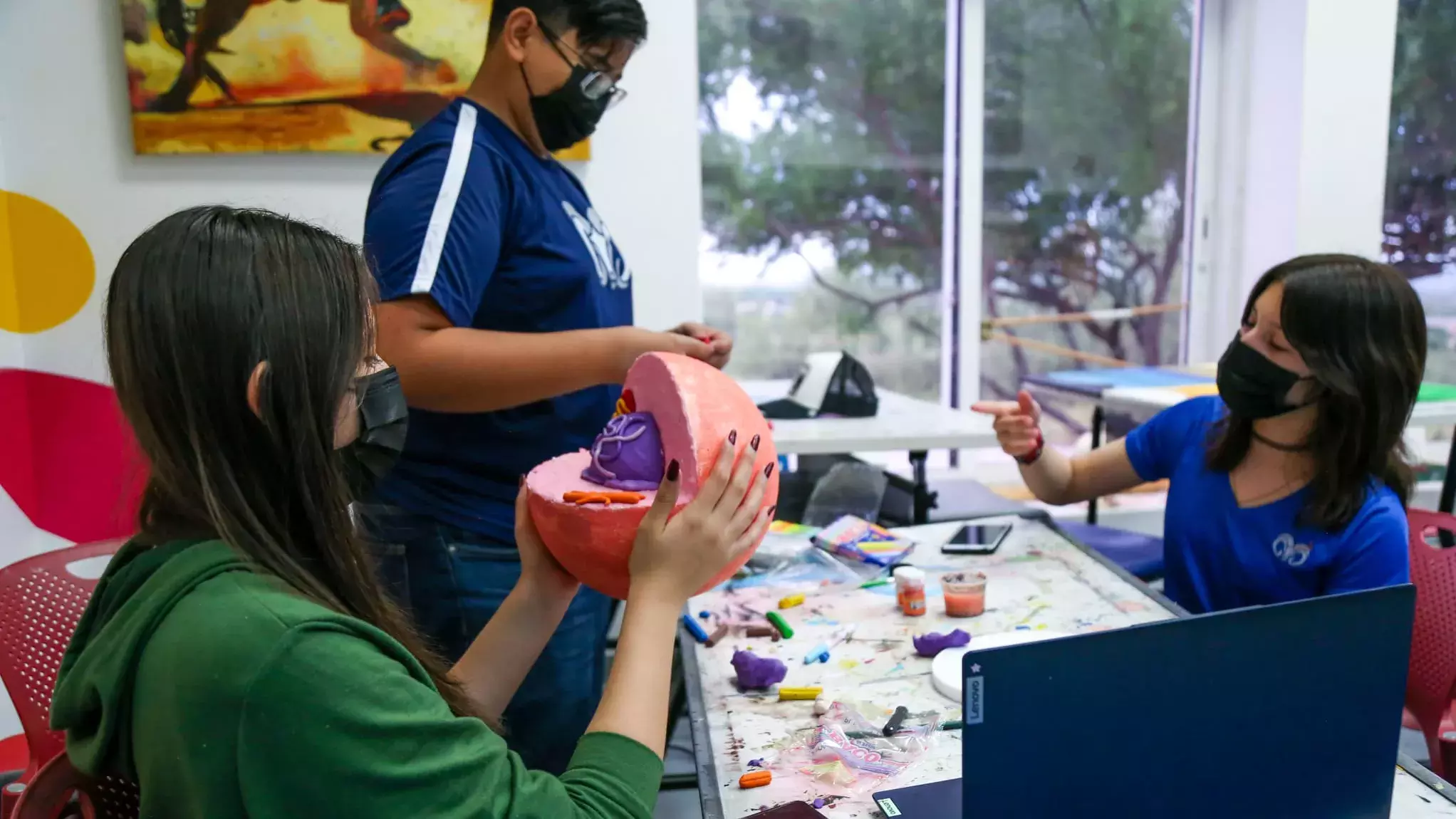 Alumnos pintando una escultura