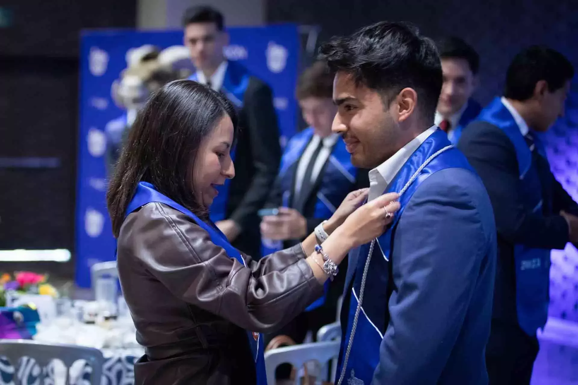 Maestra poniendo estola a graduado