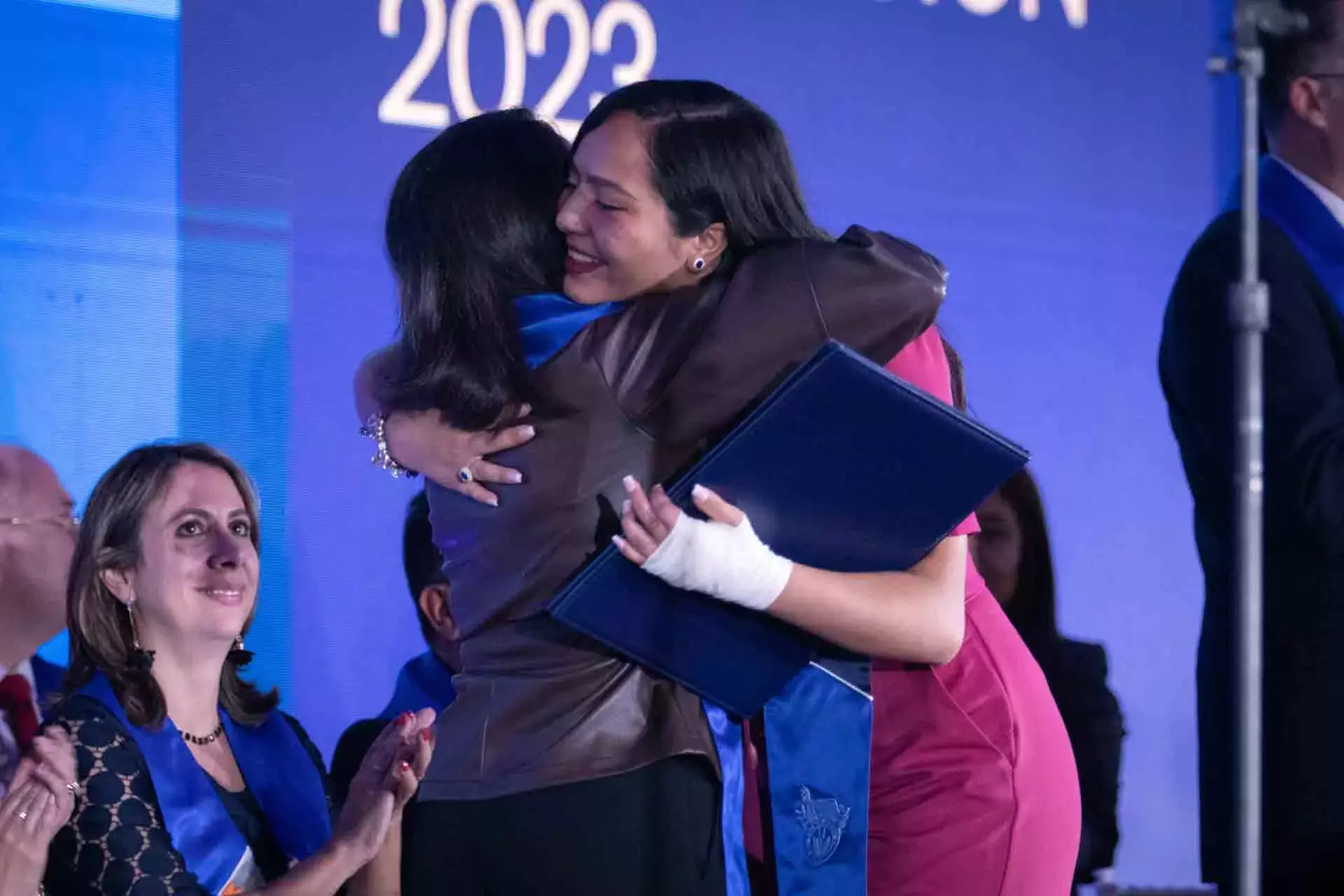 Maestra y graduada abrazándose