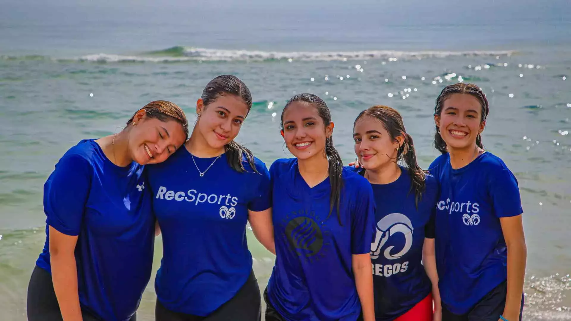 grupo de alumnas mirando a la cámara en la playa