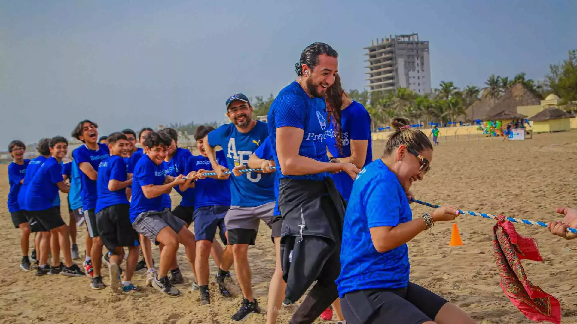 profesores jugando a la cuerda en la playa