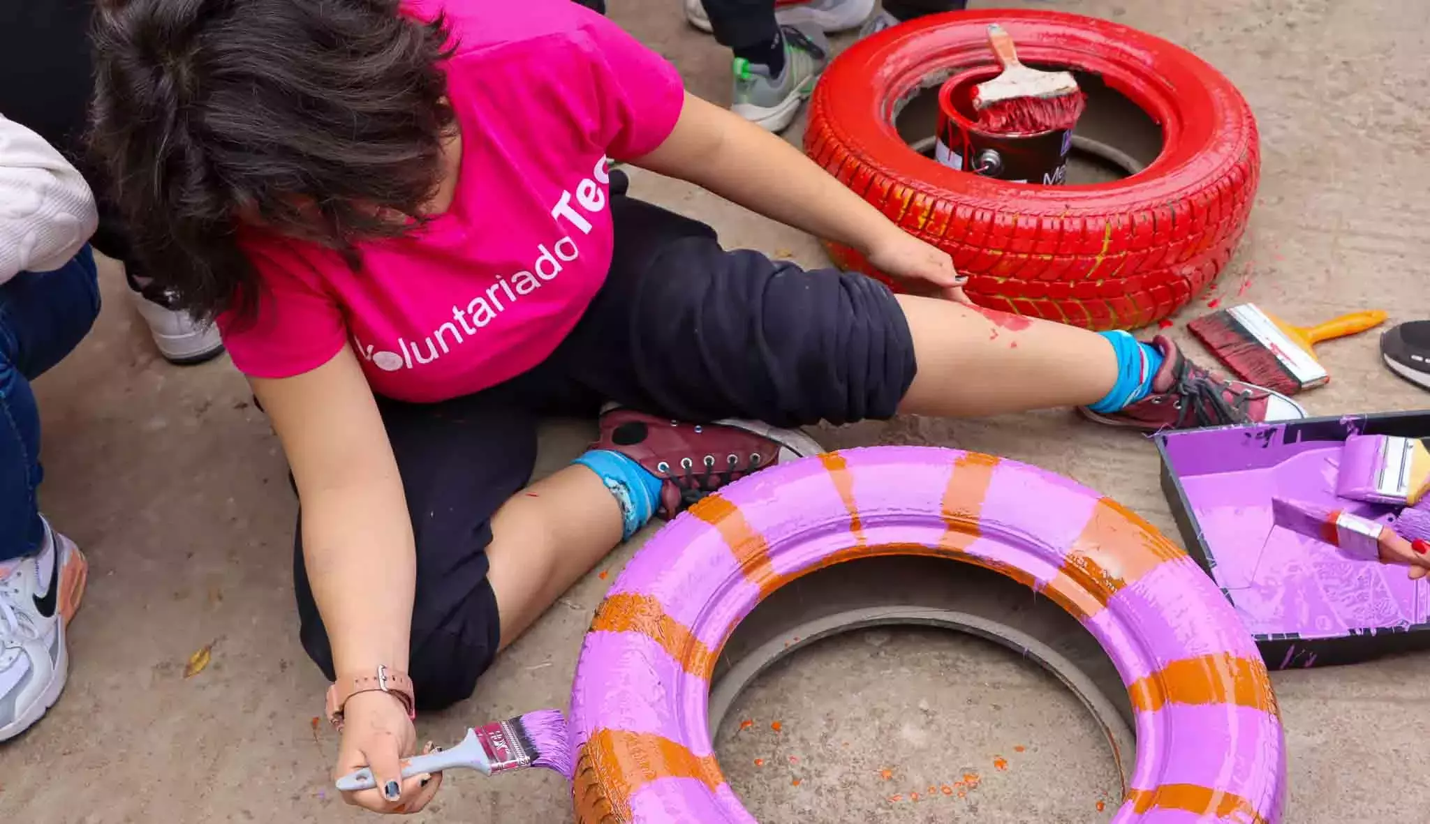 Alumnos pintando llantas en Voluntariado Tec