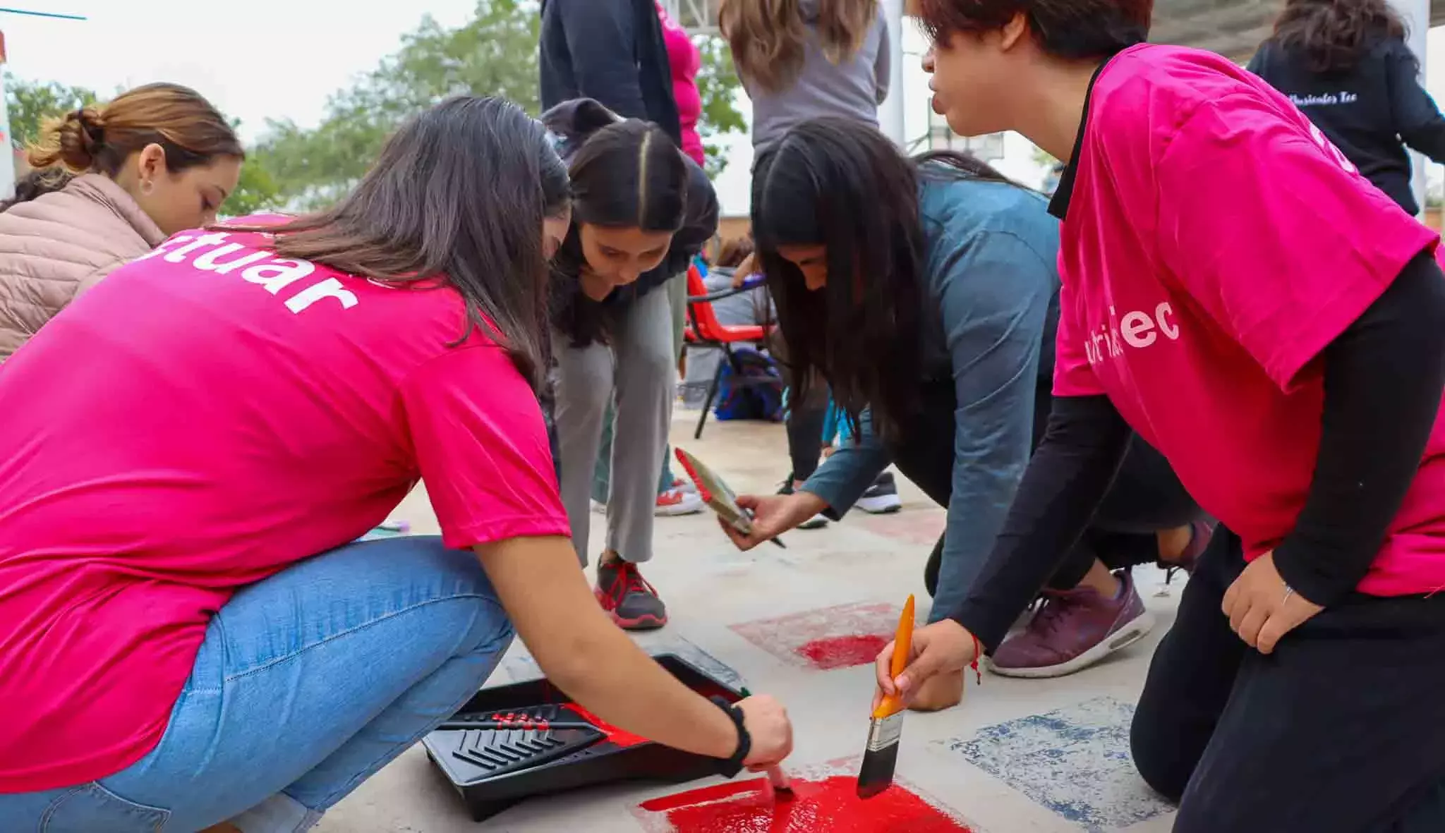 Trabajo en equipo mientras los alumnos pintan en Voluntariado Tec