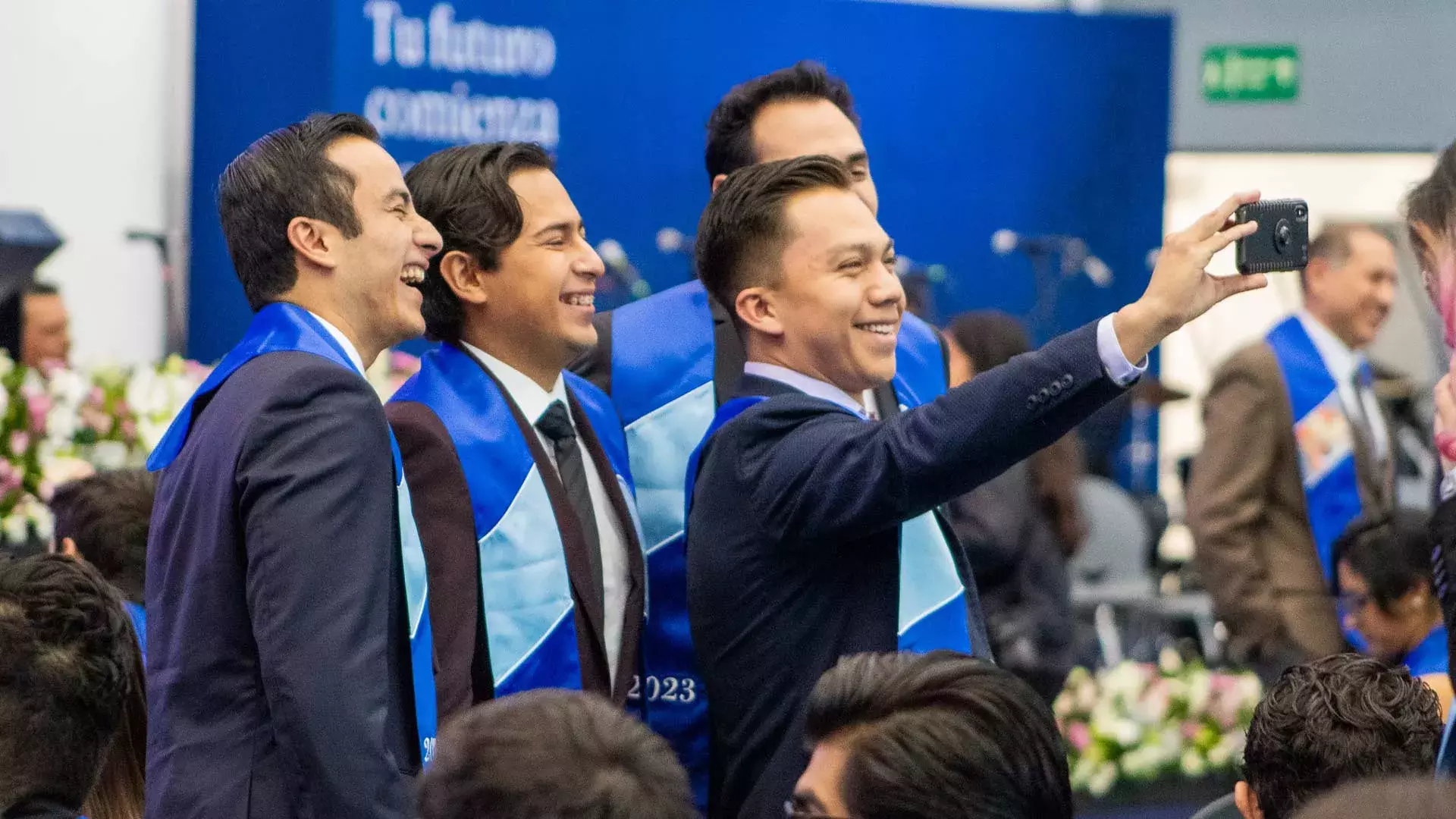 Recién graduados se toman selfie.