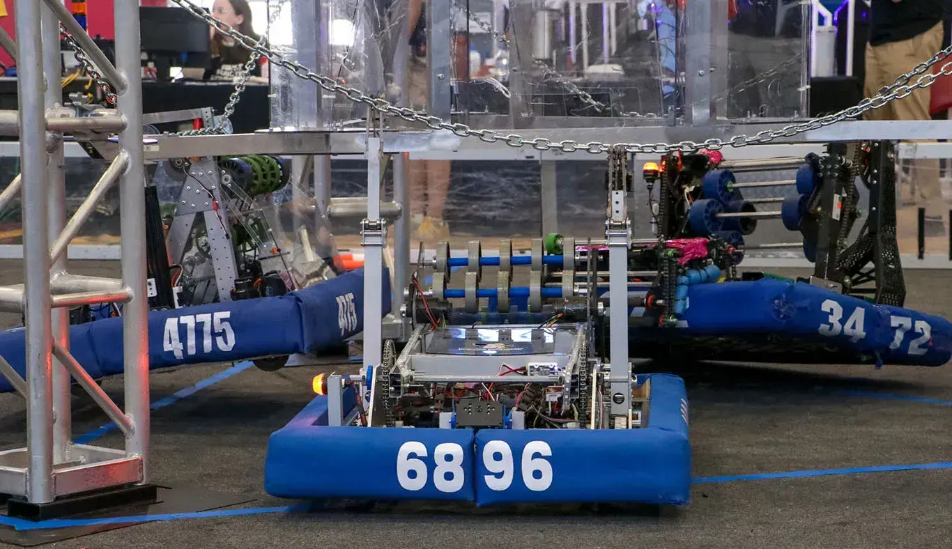 Tres robots colgados de una estructura. 