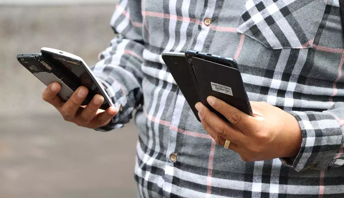 Hombre enseña los celulares que va a depositar en Reciclatec.