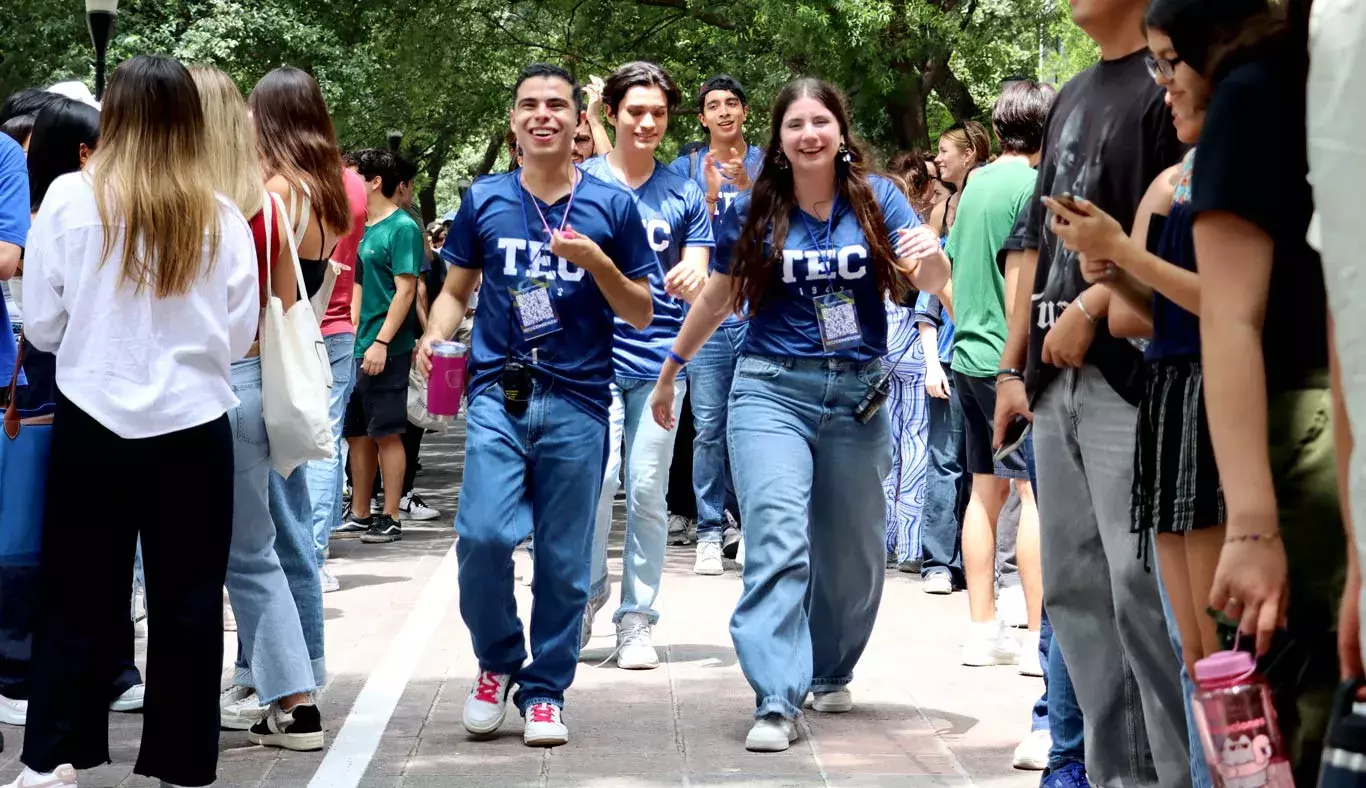 Alumnos celebran y corren a través de una valla.