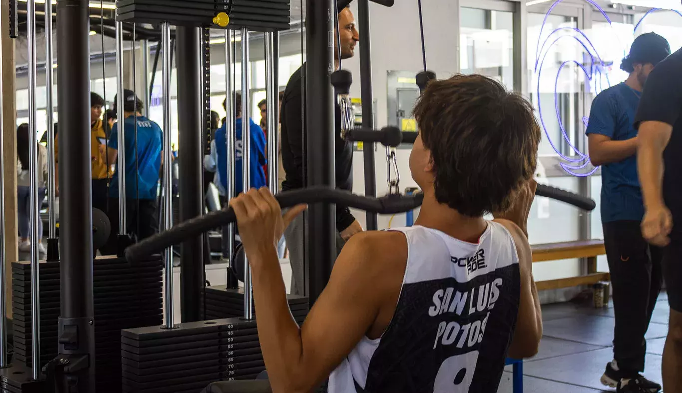 Estudiante haciendo uso de los nuevos equipos de brazo del gimnasio