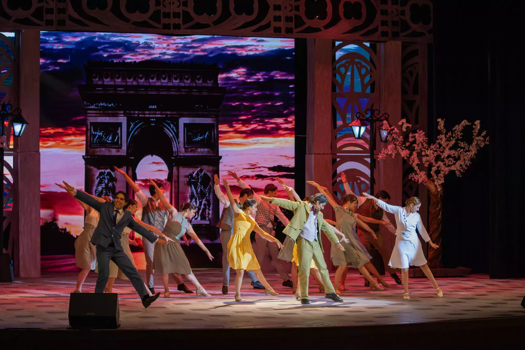 bailarinas y protagonistas de la obra bailando en el escenario, parís está de fondo 