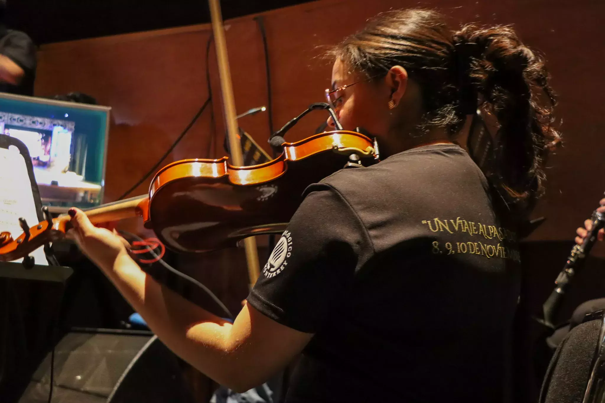 Chica parte de la compañía de música, se encuentra tocando el violín 