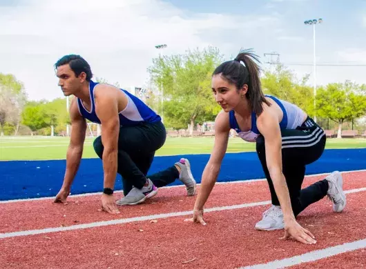 Sofia y Carlos en posición de marcas en la pista de atletismo