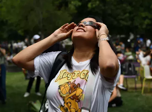 Colaboradora del Tec viendo el eclipse solar desde el Jardín de las Carreras.