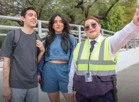 Guardia de seguridad ayudando a dos estudiantes