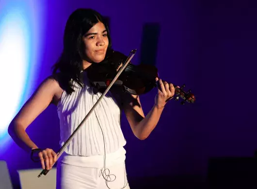 Estudiante del Tec de Monterrey vestida en blanco muestra su talento con la música tocando el violín