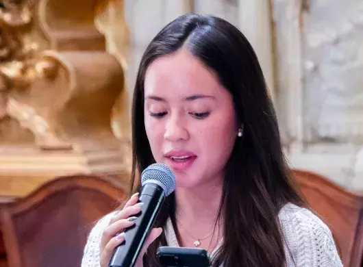 Regina Gutiérrez recitando poema en recinto