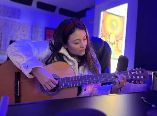 Estefania Monroy tocando la guitarra en su estudio.