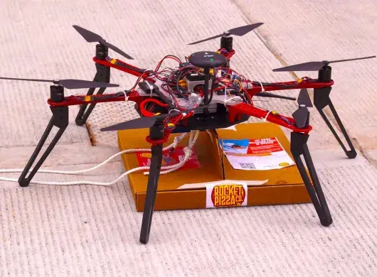 El dron "Alexa" sostiene una pizza.