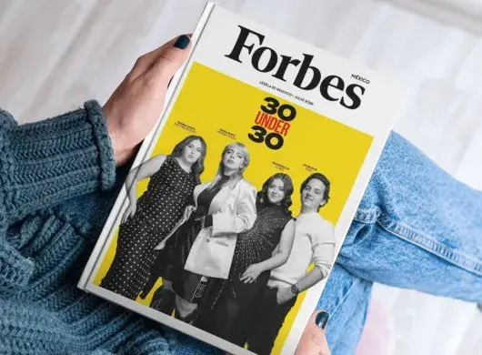 Manos de joven sosteniendo la portada de 30 Under 30 de Forbes México
