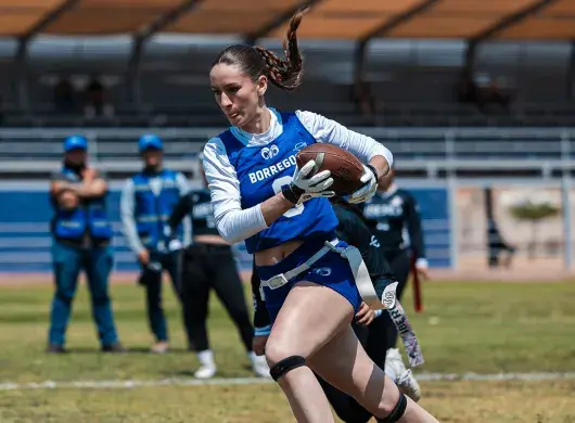Jugadora de tochito bandera de Borregos Laguna corre hacia la zona de anotación con el balón en mano