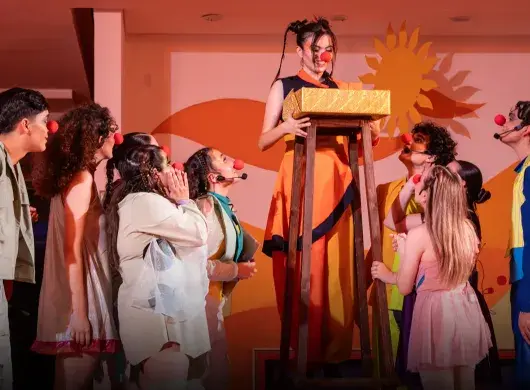 Actores con vestuarios y narices de payaso.