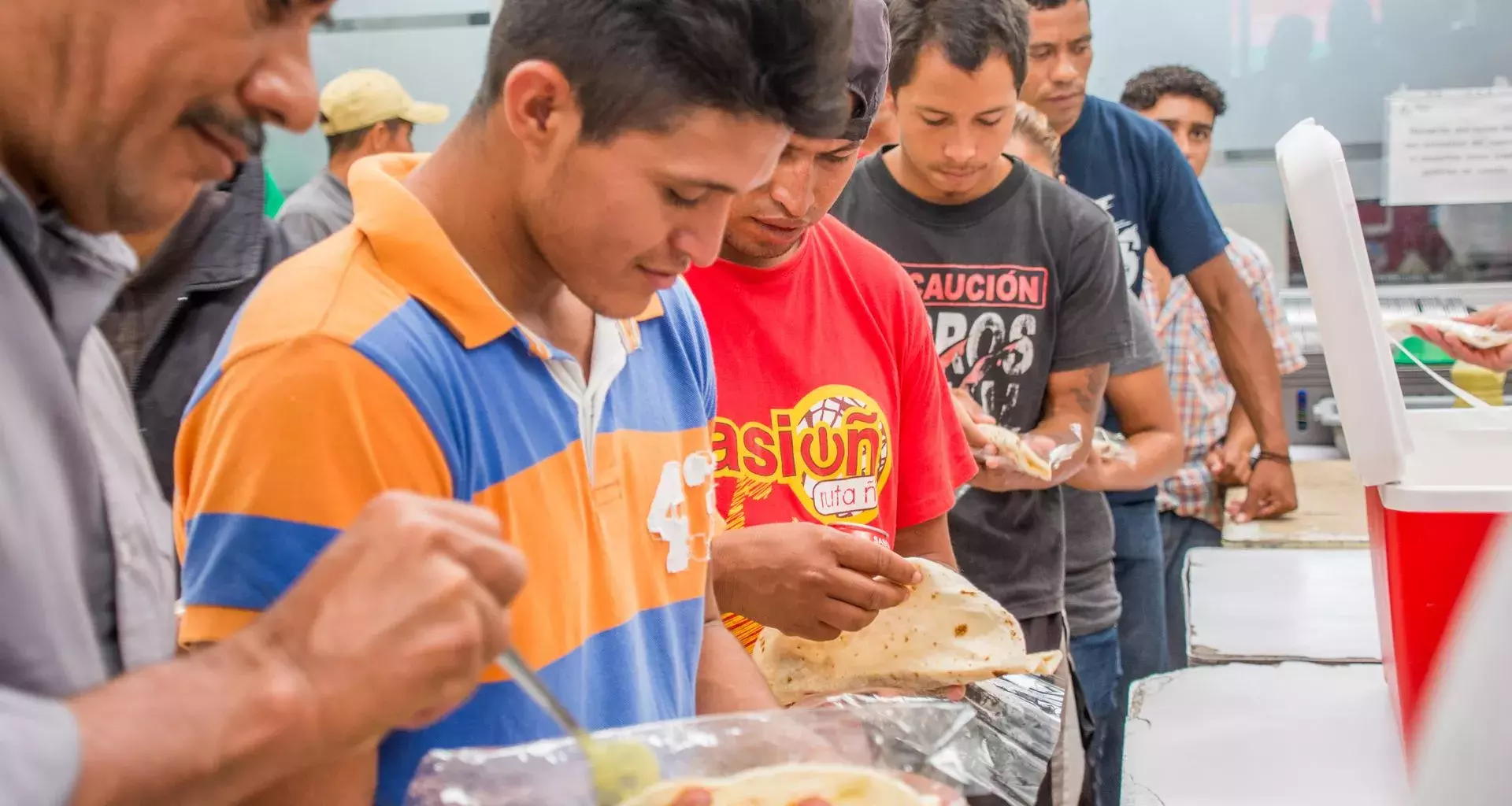 Migrantes con alimentos en las manos