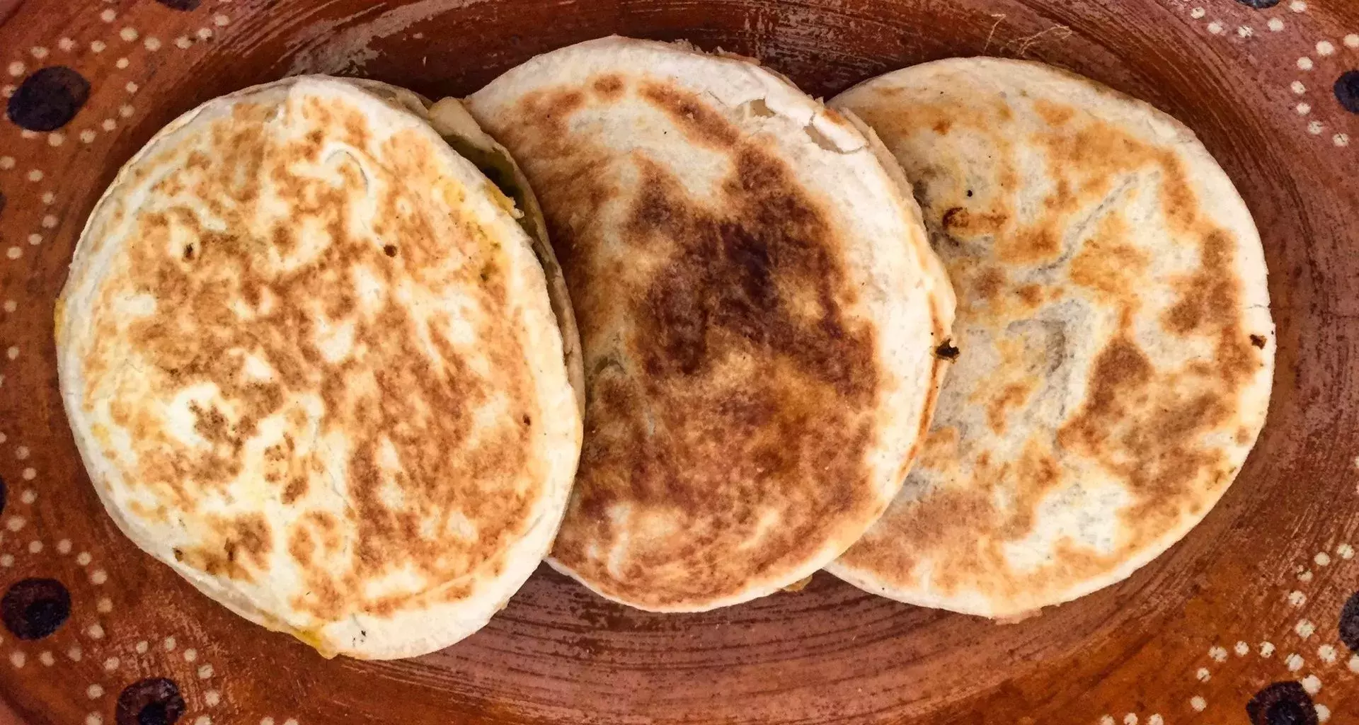 Foto de gorditas de azúcar en un plato de barro sobre una mesa