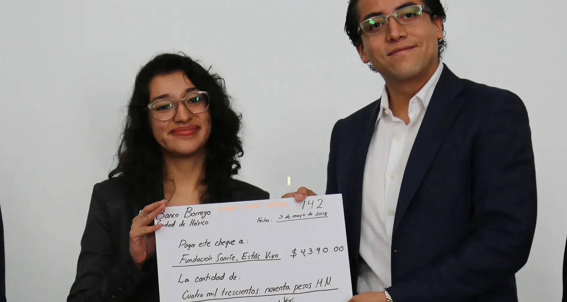 alumnos entregando cheque