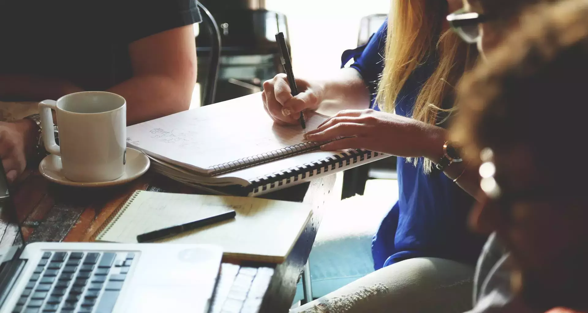 Jóvenes estudiantes en mesa de trabajo.