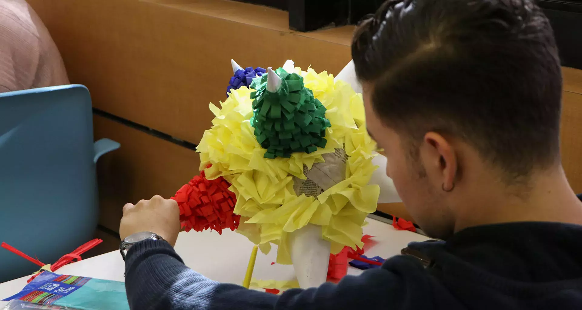 Alumnos decorando piñata en la actividad Viva México