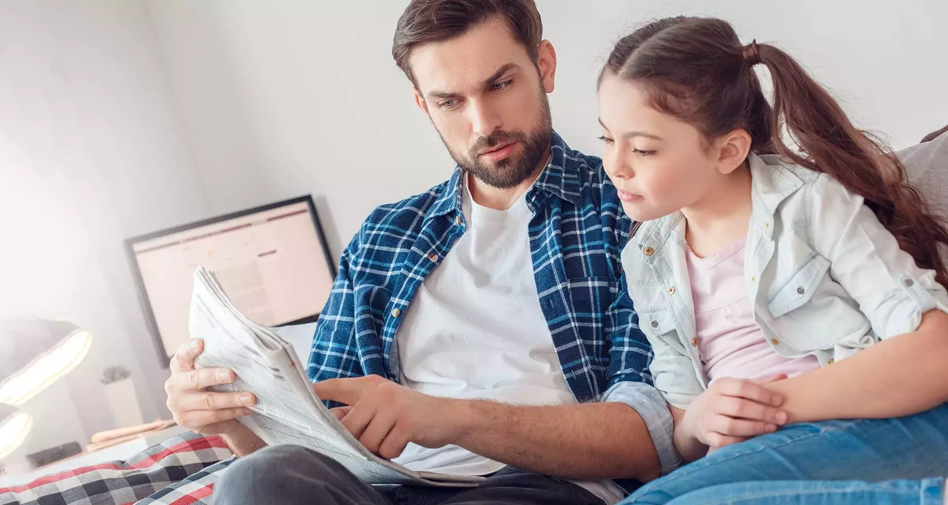 Papá explicando una noticia del periódico a su hija