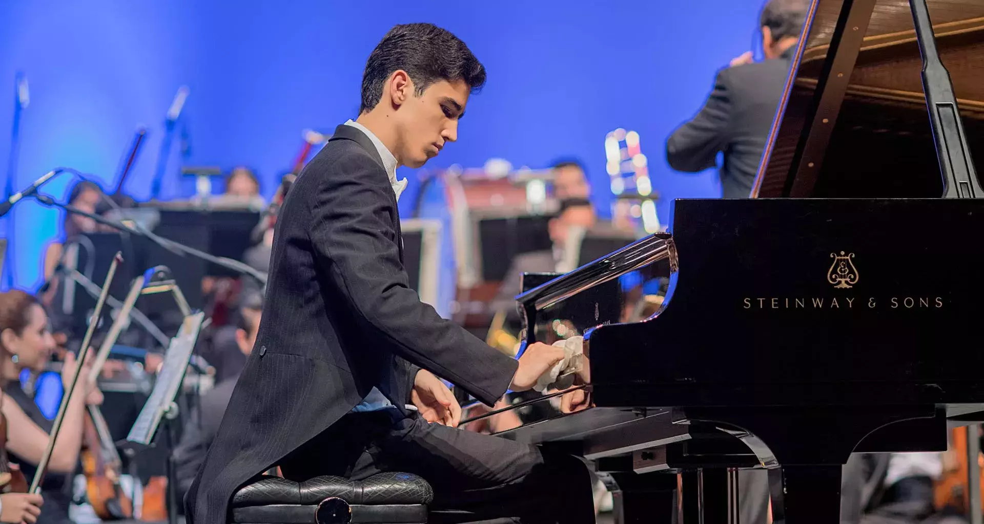 joven sentado tocando un piano