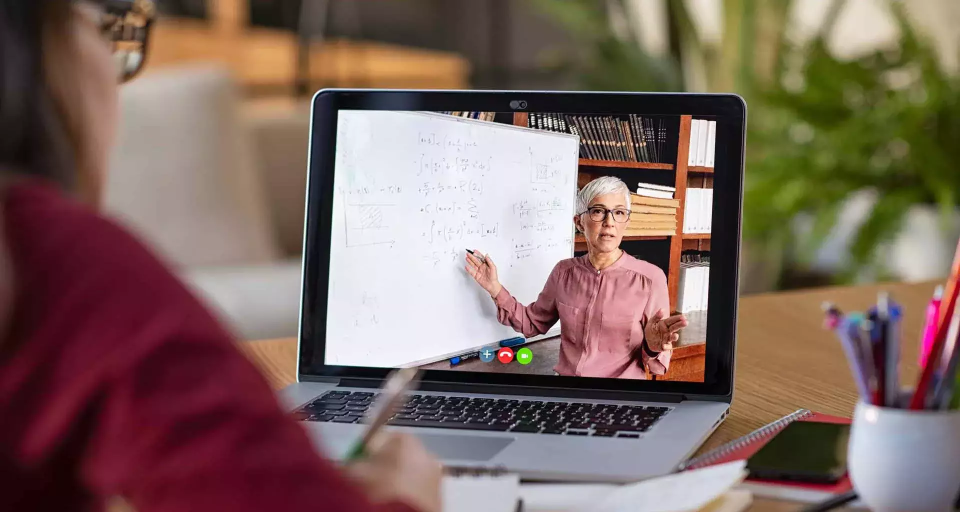 Estudiante toma una clase en línea y observa explicación de maestra