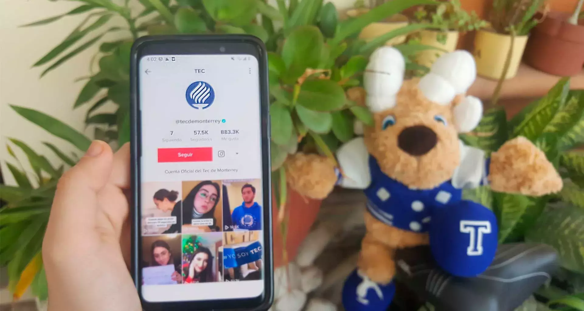 Teléfono móvil con cuenta TikTok del Tecnológico de Monterrey y Teus de fondo