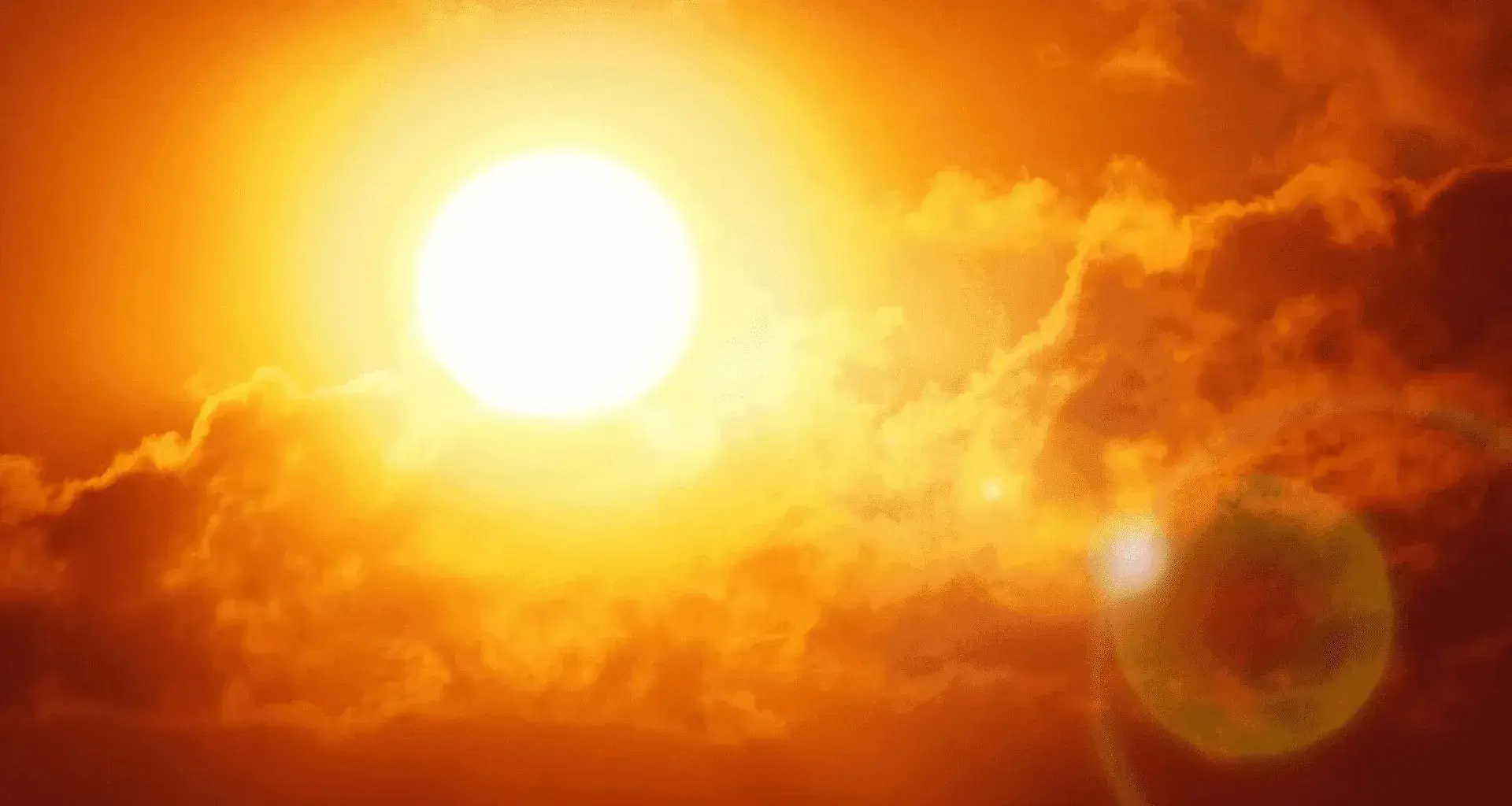 Fotografía del sol reflejando sus rayos en el cielo con tonalidades rojizas/naranjas por altas temperaturas.