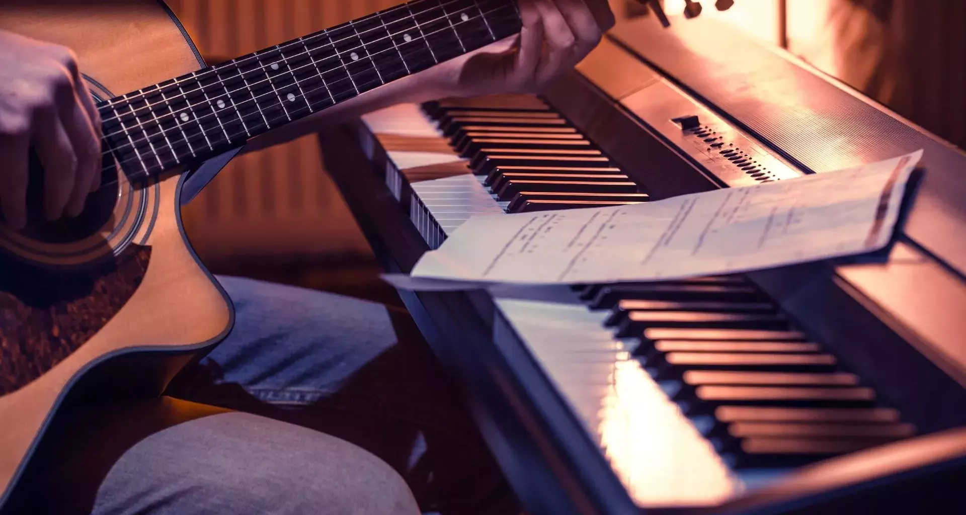 hombre-tocando-guitarra-junto-a-un-teclado