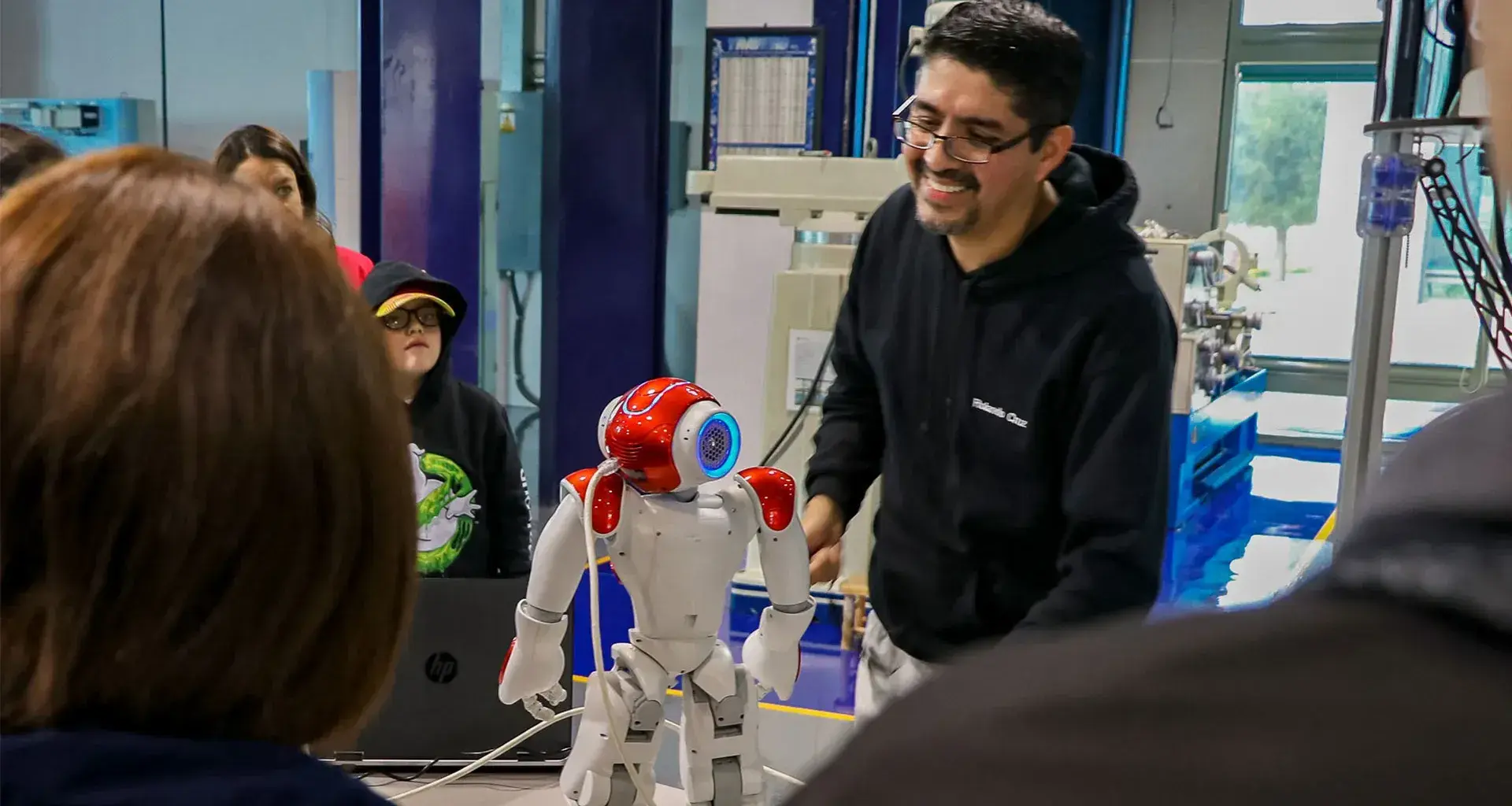 Profesor Rolando Cruz presentando robot NAO frente a estudiantes antes de la pandemia