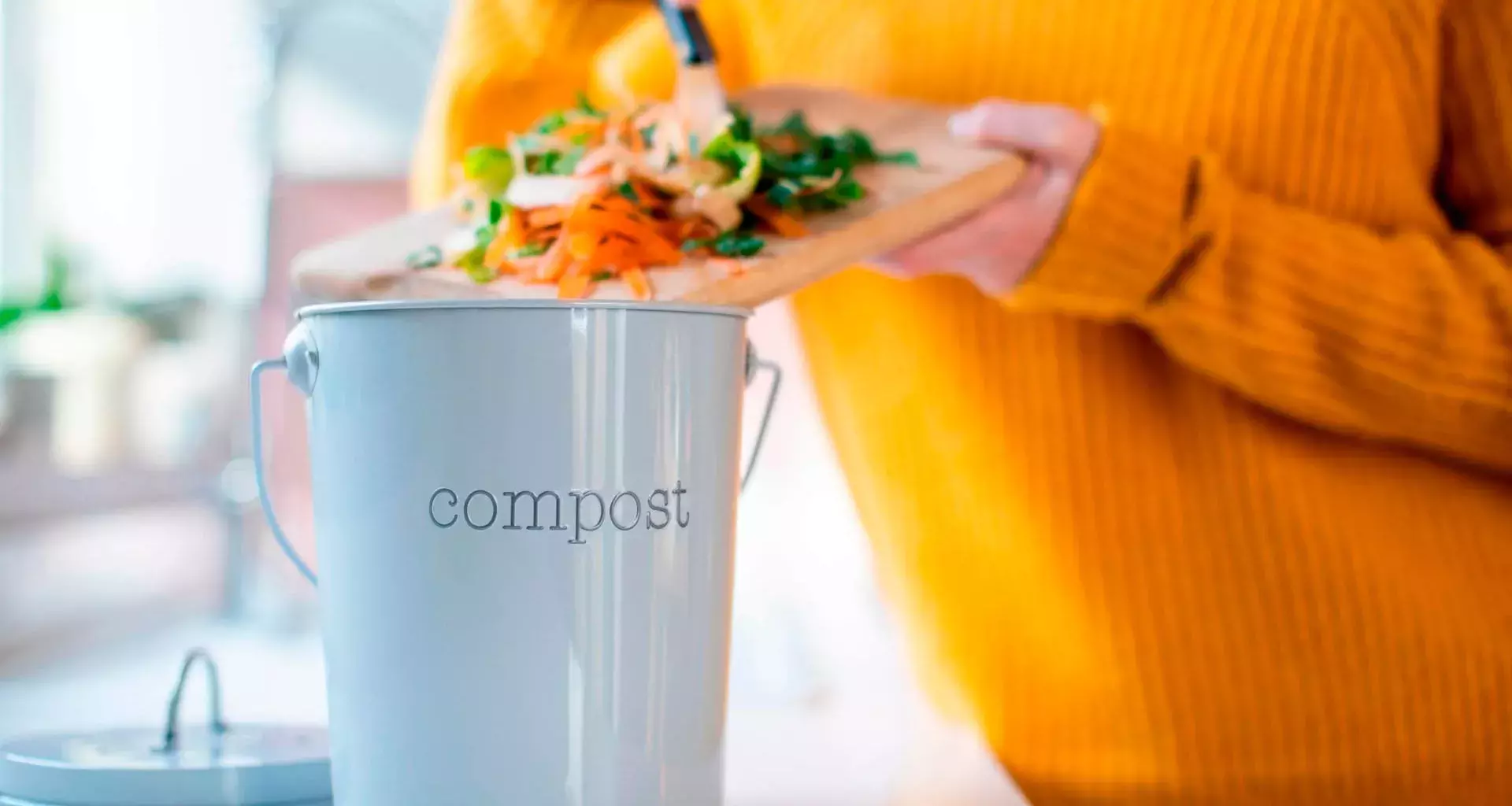 Mujer aprovechando los desechos vegetales de su cocina para hacer composta