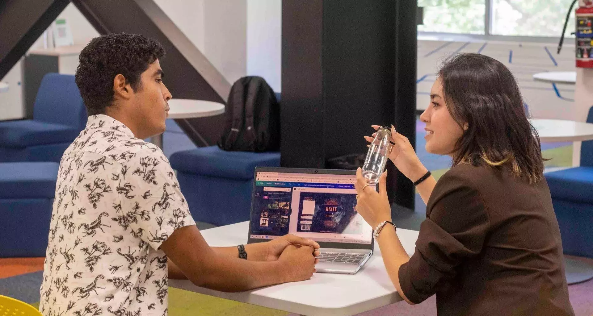 carlos y alicia explicando su proyecto con una computadora