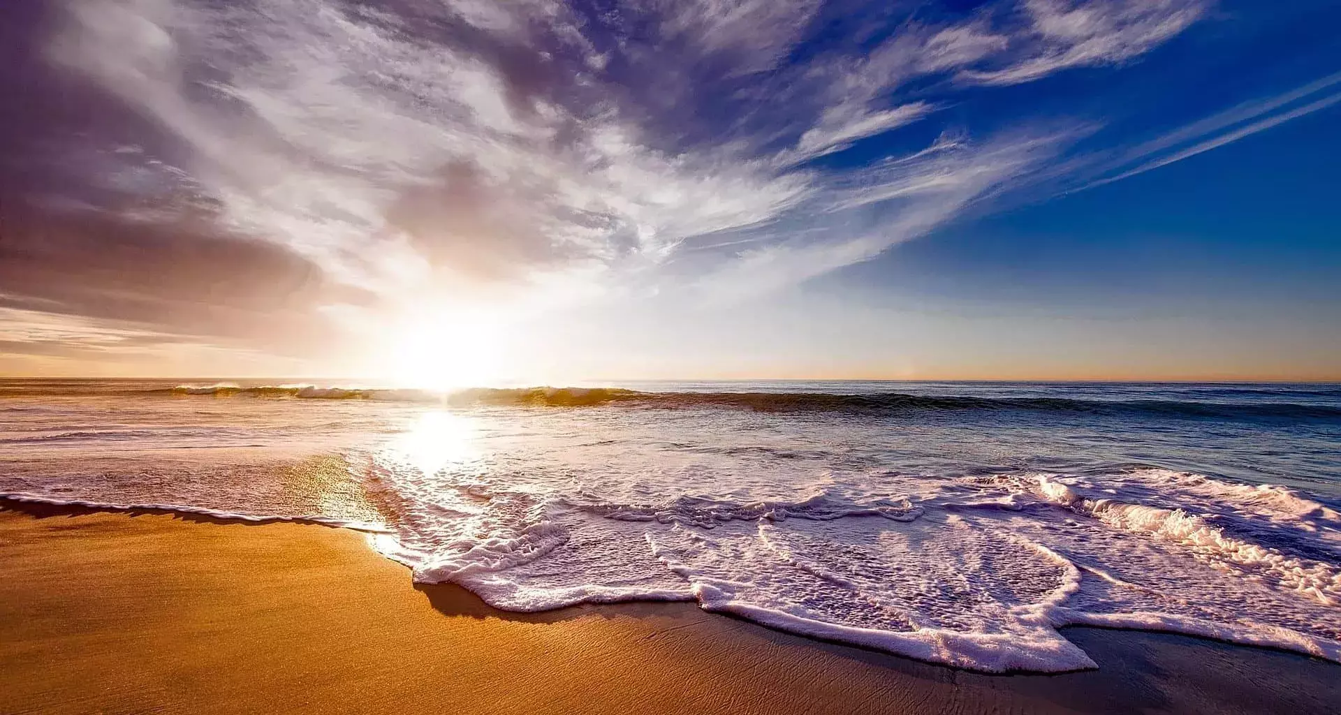 Vista de la playa con el sol de fondo