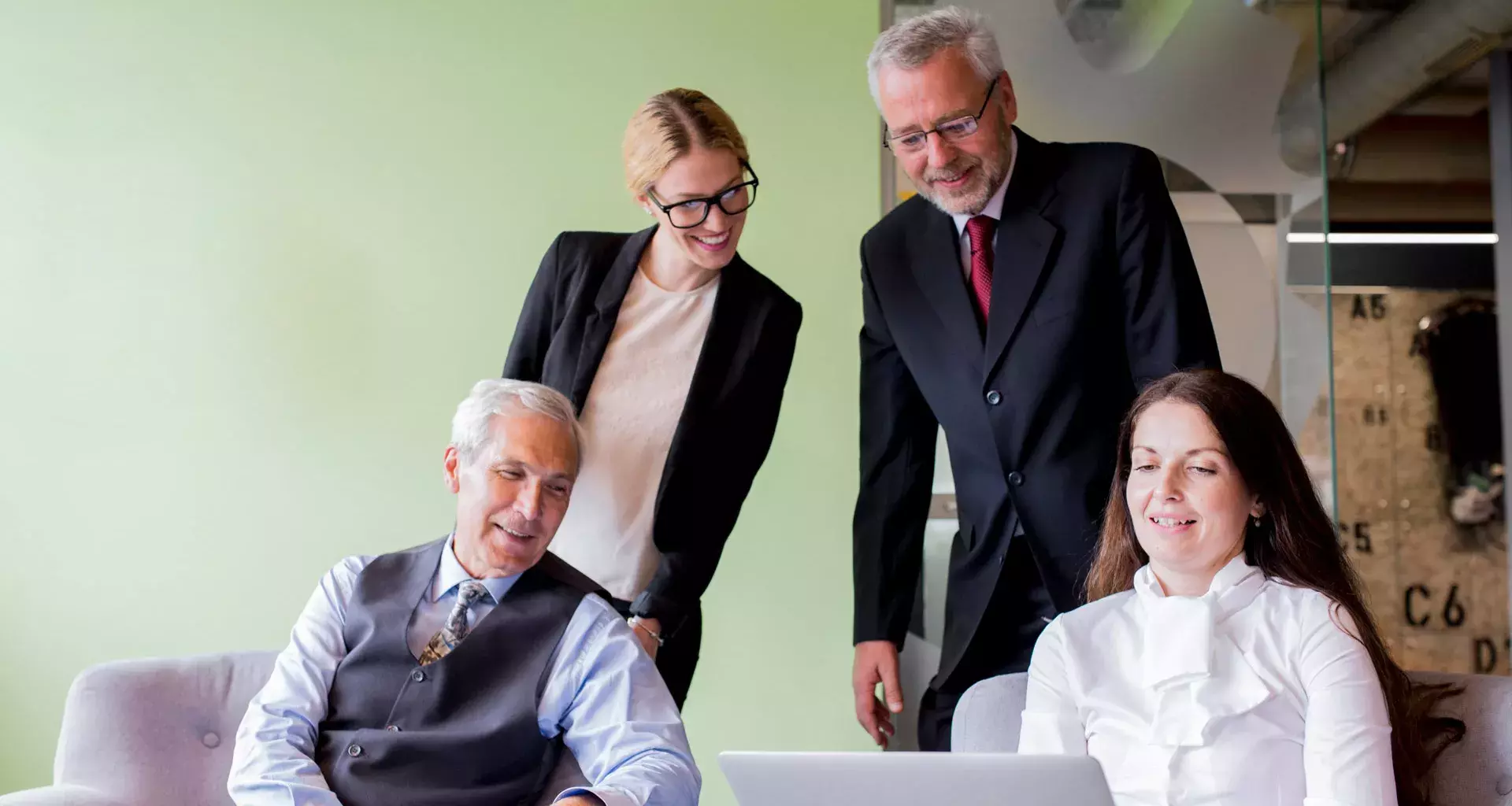 familia empresaria viendo laptop en reunion que busca trascendencia familiar