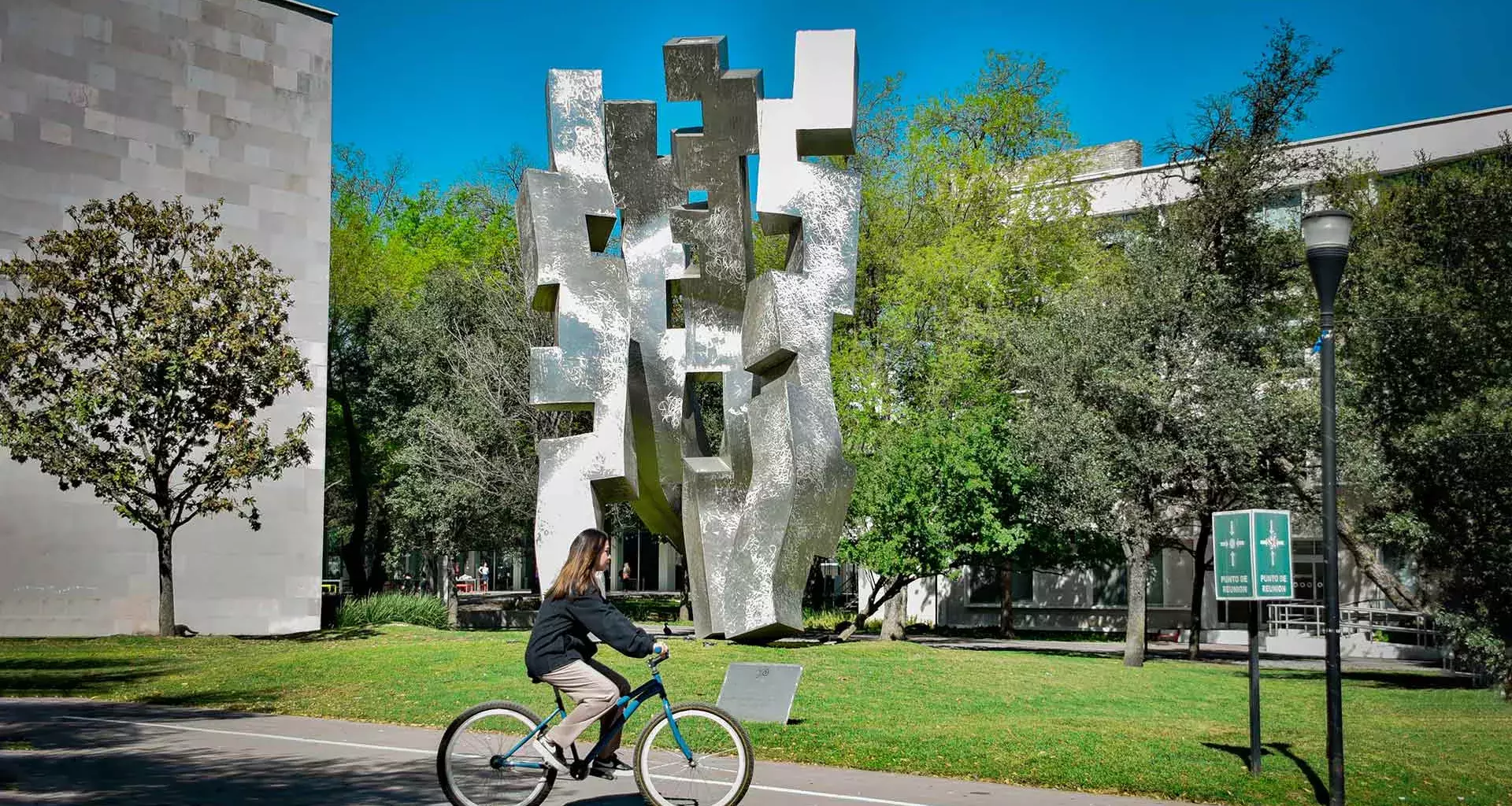 Estudiante del Tec, campus Monterrey, transportándose en bicicleta dentro del campus