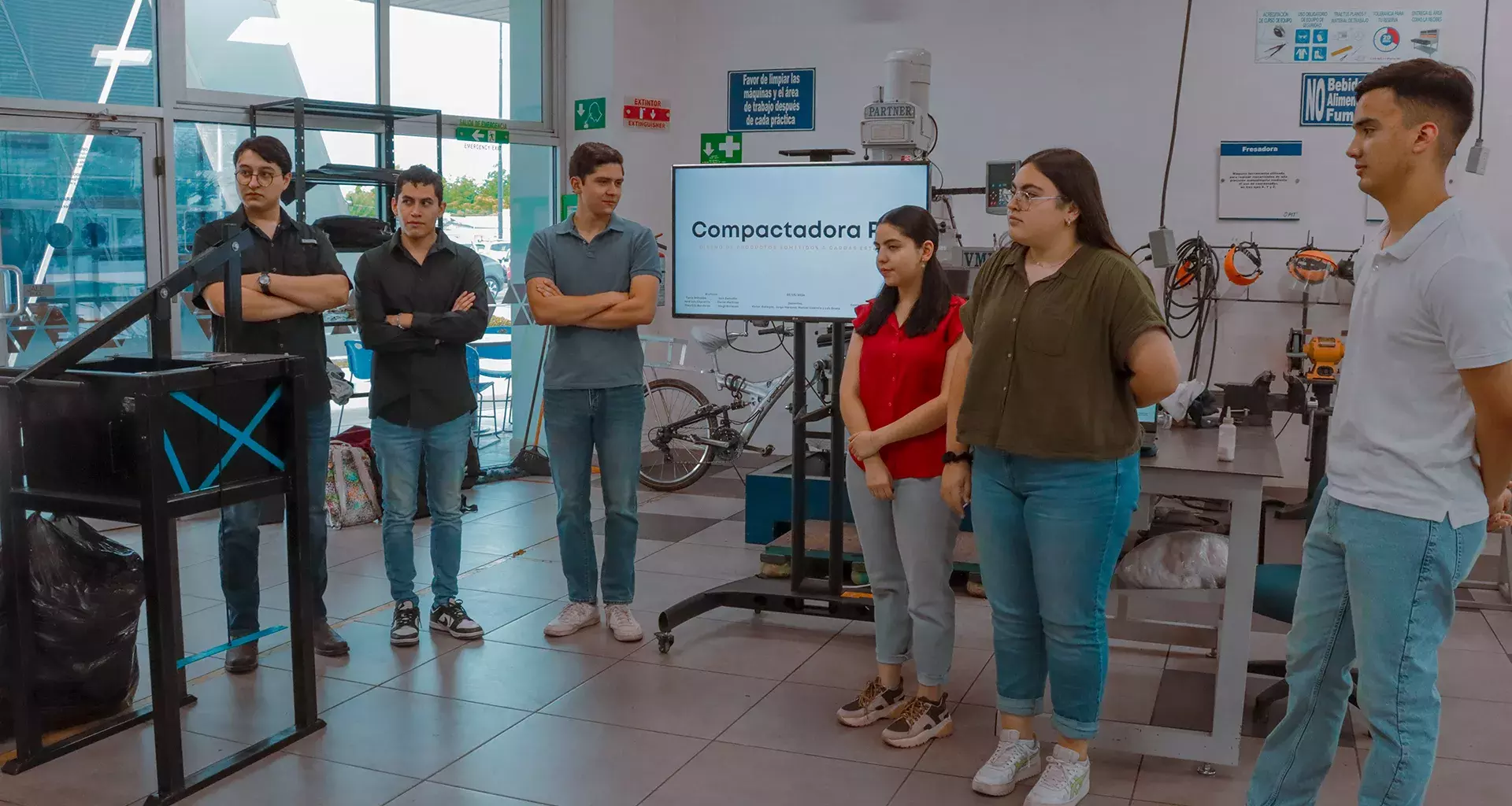 Estudiantes del Tec de Monterrey usando la compactadora de PET