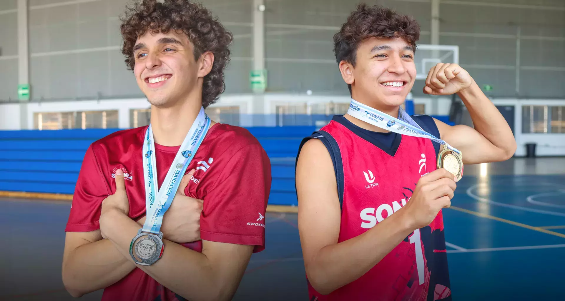 Dos jugadores de basquetbol posando con sus medallas del Nacional CONADEP en la Arena Borregos