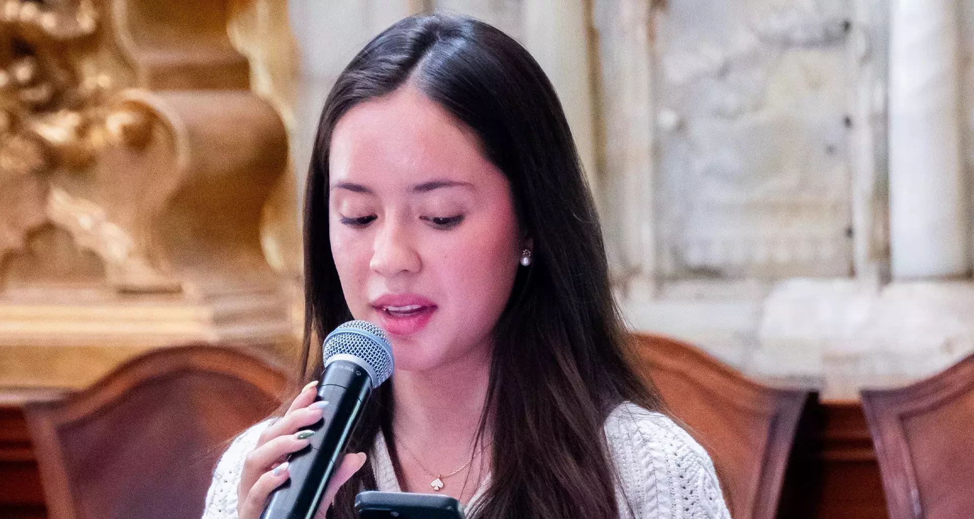 Regina Gutiérrez recitando poema en recinto