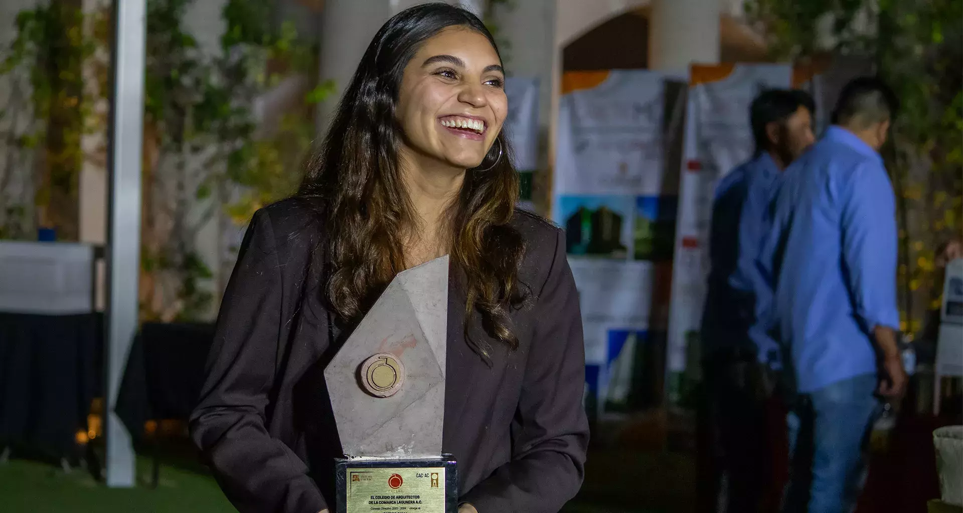 Egresada de Arquitectura del Tec de Monterrey campus Laguna sonríe al recibir premio Calli del Colegio de Arquitectos de la región