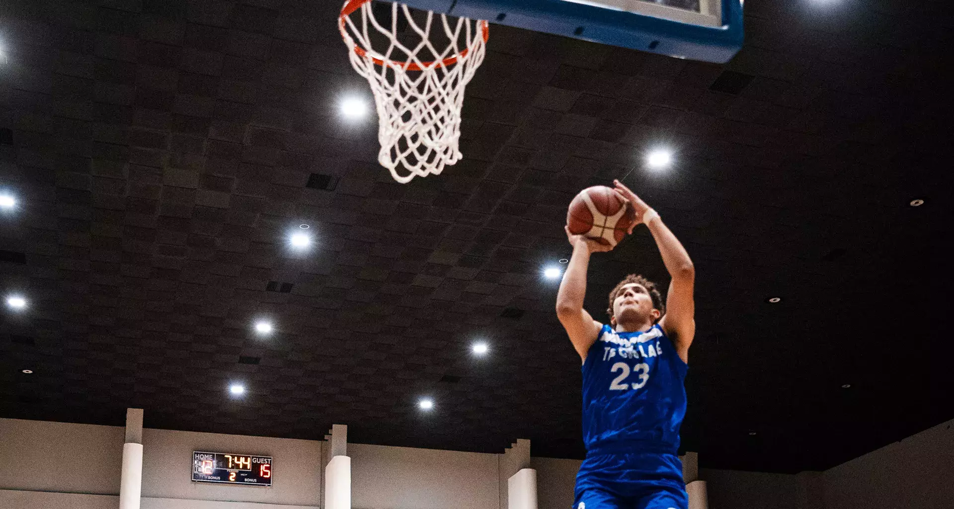 Jugador de Borregos Laguna salta y lanza balón de básquetbol para encestar