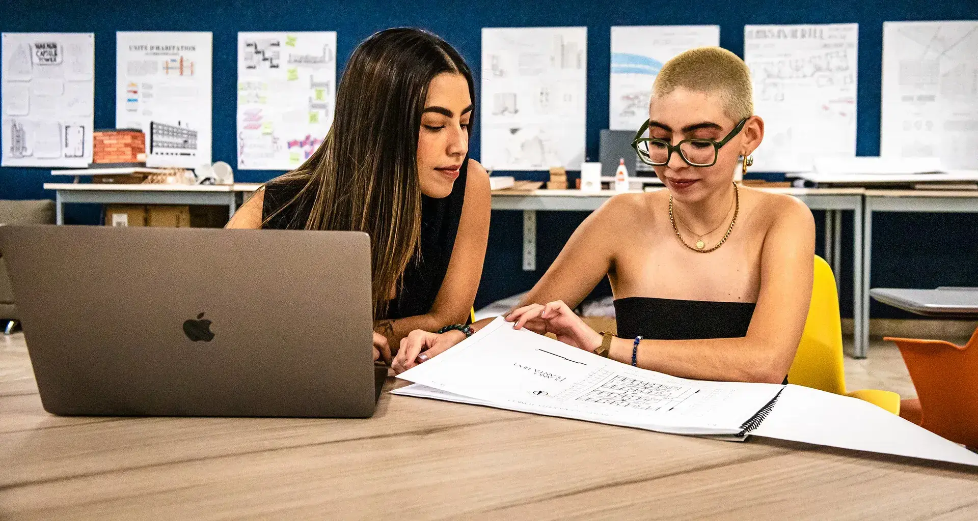 Estudiantes de arquitectura comparten mesa de trabajo con laptop y planos en el Tec de Monterrey campus Laguna