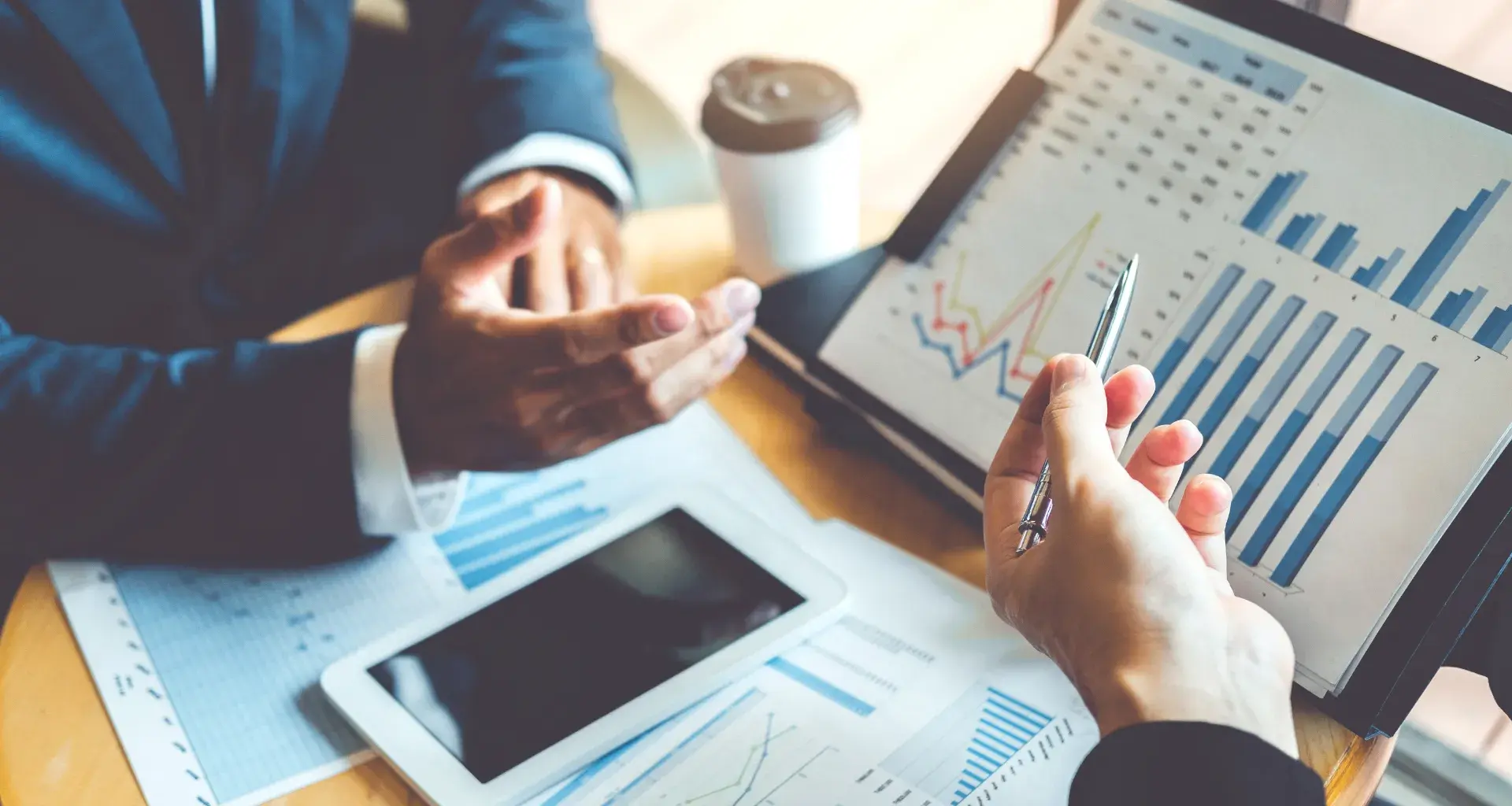 Personas analizando gráficos y datos financieros