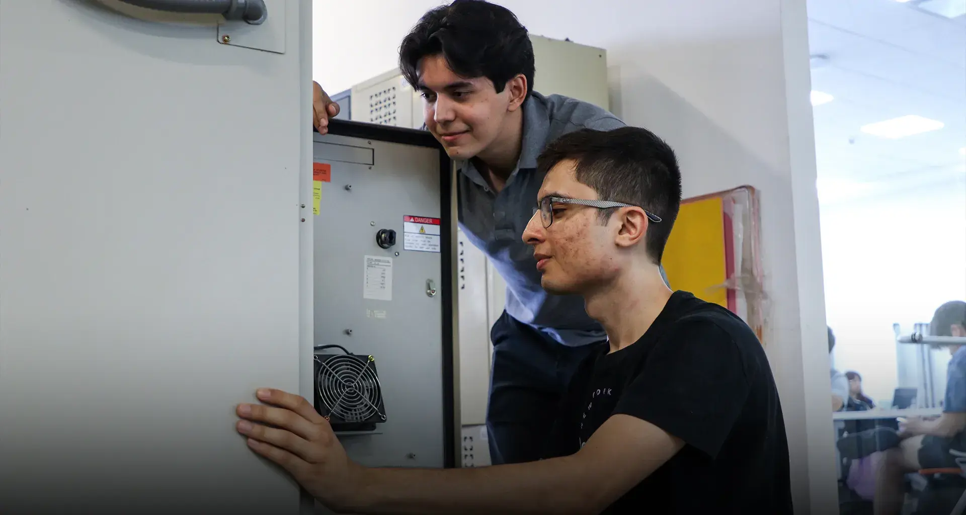 Dos estudiantes analizan los circuitos de una caja.